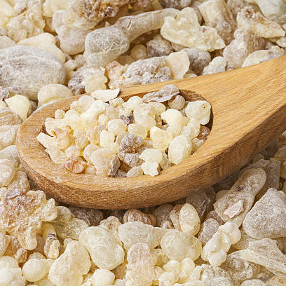 Wooden spoon filled with resinous substance on a bed of similar material